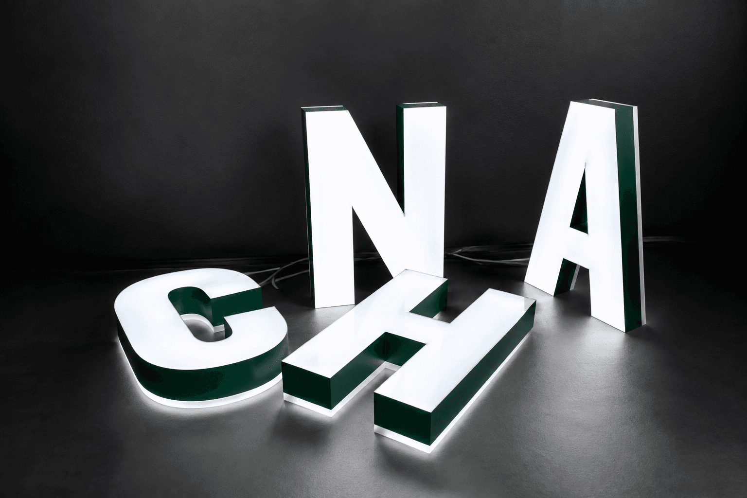 Front-lit and halo-lit channel letters displayed against a dark wall
